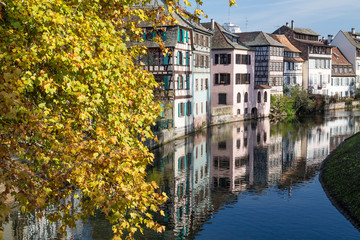 Traditional timber houses in Little France, Strasbourg with autumnal tree and river