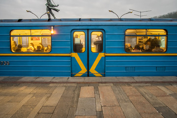 Blue subway train at the station in cloudy evening. 