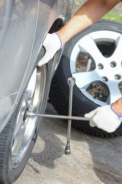 A After A Breakdown, A Person Changes A Wheel On A Car To Another Wheel With A Wrench