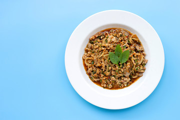 Spicy mince pork salad on blue bakcground.