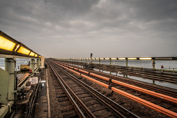 Fototapeta premium Open subway way at dusk, illuminated by lamps.