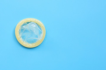 Condom on blue background. Copy space