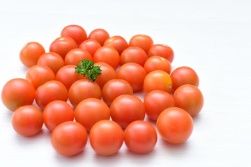 Fresh cherry tomato, displayed in containers on white wooden background