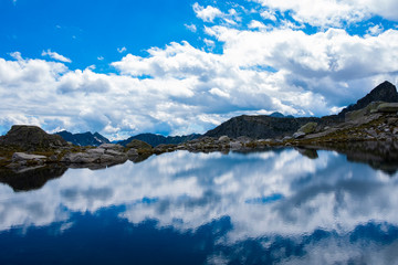 MOUNTAINS AND CLOUDS REFLECTED ON LAKE
