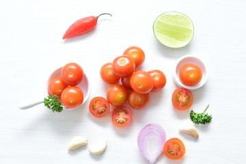 Fototapeta premium Fresh cherry tomato, displayed in containers on white wooden background