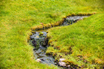 Wonderful icelandic nature landscape. View from the top. High mountains, mountain river and green grassland. Green meadows. Iceland.