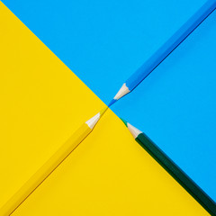 Yellow, blue and green pencils. Concept of blending primary colours. Minimal Aesthetic.