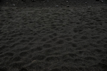 Black sand floor texture from above. Background.