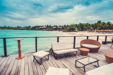 Outdoor terrace with Empty wooden table and chair with Sea view of Indain ocean, Maldives background. Chairs, table and sofa at the Terrace with panorama view of sea.
