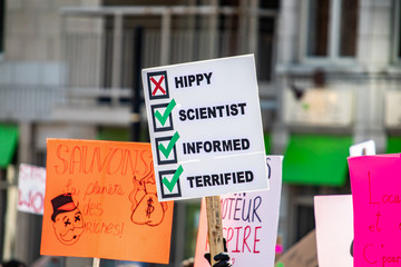 Not hippy, an informed and terrified scientist poster is seen during an environmental rally on an urban street, scared for future and climate decline