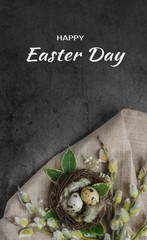 Happy Easter quail eggs in a nest on a dark stone background with green leaves and willow branches.Banner, Billboard or greeting card.Easter sale in the store.minimalism.Zero Waste.copyspace