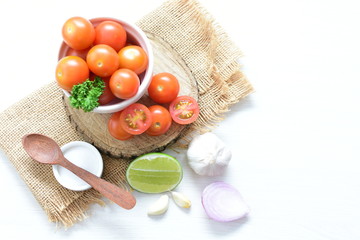 Fresh cherry tomato, displayed in containers, on cloth background