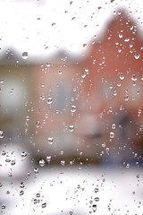 Drops of water on a window glass during snowy day