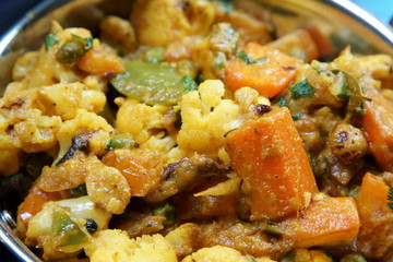 Mixed vegetable curry in a dish on a wooden blue background, with copy space.