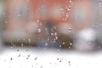 Drops of water on a window glass during snowy day