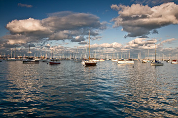 Sailboats rest peacefully at their moorings as the sun sets on Burnham Harbor, Chicago lakefront.