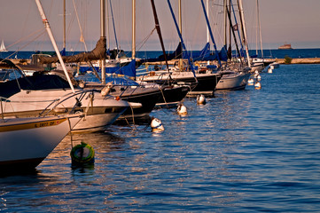 Sailboats rest peacefully at their moorings as the sun sets on Monroe Harbor, Chicago lakefront.