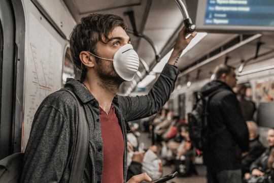 Young male in protective mask in subway train. Health awareness for protection