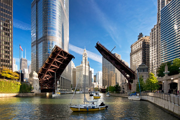 The raising of the bridges on the Chicago River signals the end of another sailing season as sailboats move from their harbor on Lake Michigan to their winter dry dock location. - obrazy, fototapety, plakaty