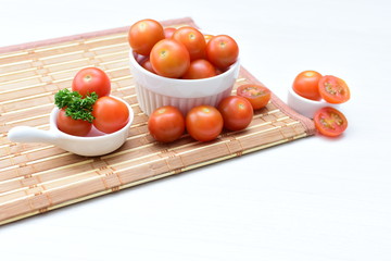 Fresh cherry tomato, displayed in containers on wooden background