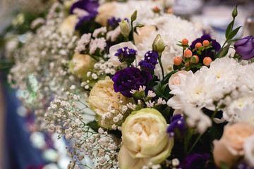 Obraz na płótnie Canvas Close up of beautiful and stylish bouquet fresh white flowers and purple roses. Summer floral composition on holiday table. Elegant arrangement floristics setting