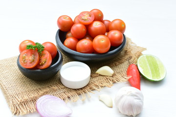 Fresh cherry tomato, displayed in containers, on cloth background