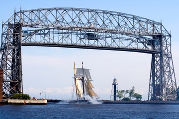 Pride of Baltimore II Tall Ship sailing under the Aerial Lift Bridge in the Duluth Port of Lake Superior Canal Park. Duluth Minnesota MN USA