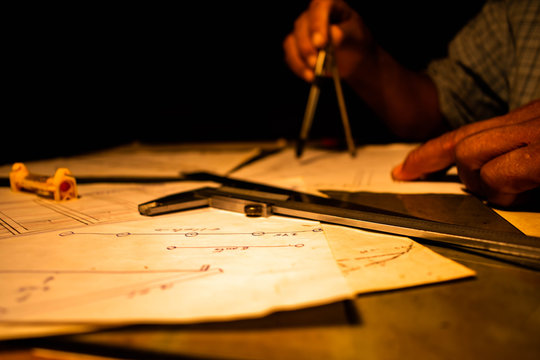 Arquitecto usando sus herramientas sobre planos.