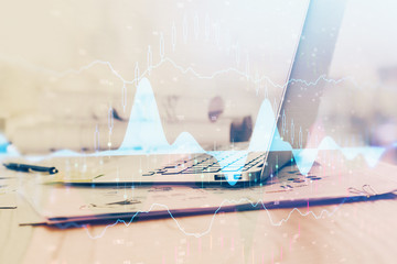 Forex graph hologram on table with computer background. Multi exposure. Concept of financial...