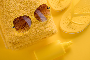 Sunglasses, sunscreen spray, towel, flip-flops