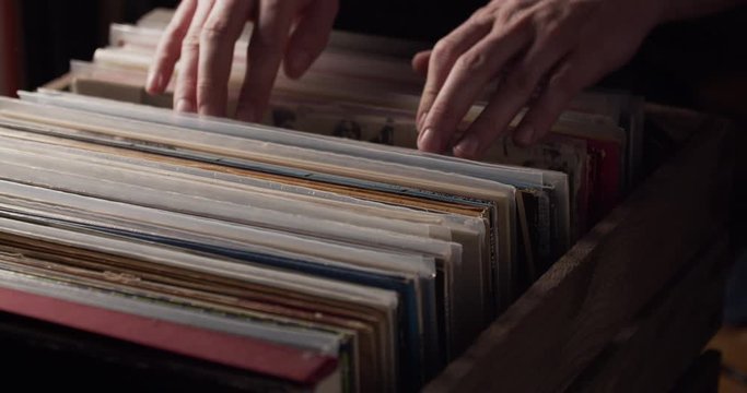 Closeup of Hands searching Vinly Records from Stack and pulling one out