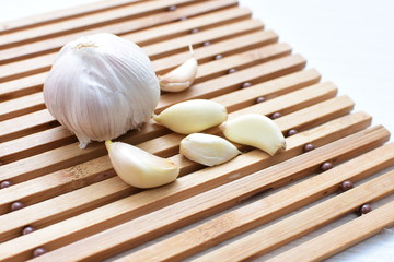 Heads of garlic, ripe white corsage on white wooden background