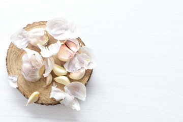 Heads of garlic, ripe white corsage on white wooden background