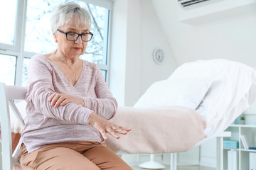 Senior woman suffering from Parkinson syndrome in clinic