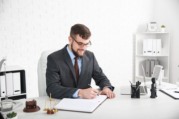 Male lawyer sitting at workplace in office