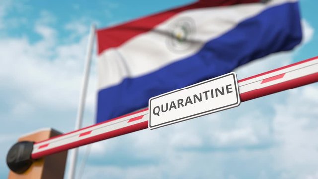 Barrier gate with QUARANTINE sign being closed with flag of Paraguay as a background. Paraguayan Border closure or infection related isolation