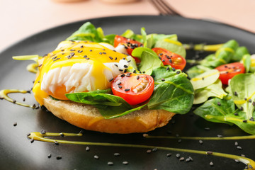 Tasty egg Benedict on plate, closeup