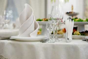 Server table plate knife fork and wine glasses at the banquet. Luxurious elegant dinner at the...