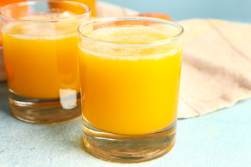 Glasses of fresh vegetable juice on color background