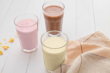 Glasses of tasty milkshakes on table