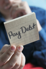 pay debt word written on notepad with pen on table 