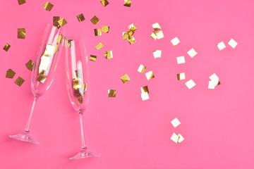Glasses for champagne with confetti on color background