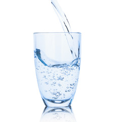 Pouring of fresh water in glass on white background