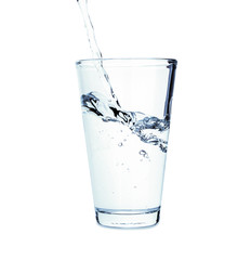 Pouring of fresh water in glass on white background