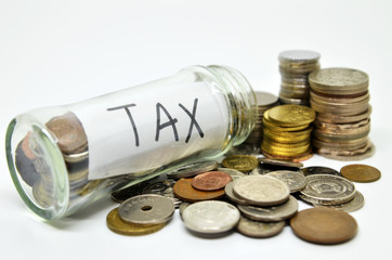 Tax lable in a glass jar with coins spilling out