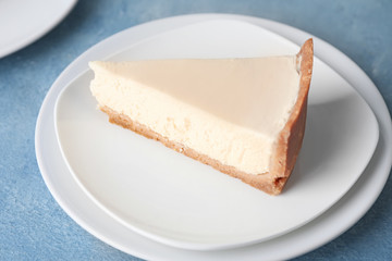 Plate with piece of sweet tasty cheesecake on table