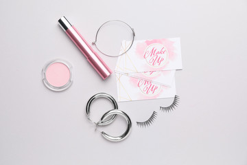 Decorative cosmetics and accessories with business cards of makeup artist on white background
