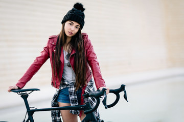 Young teenage girl waits on her bike with challenging look. School absenteeism concept