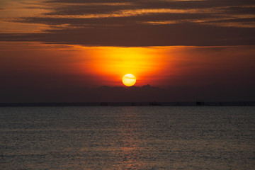 Naklejka premium The morning sunrise at the beautiful seashore has a fisherman's boat to go fishing.