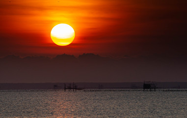 The morning sunrise at the beautiful seashore has a fisherman's boat to go fishing.